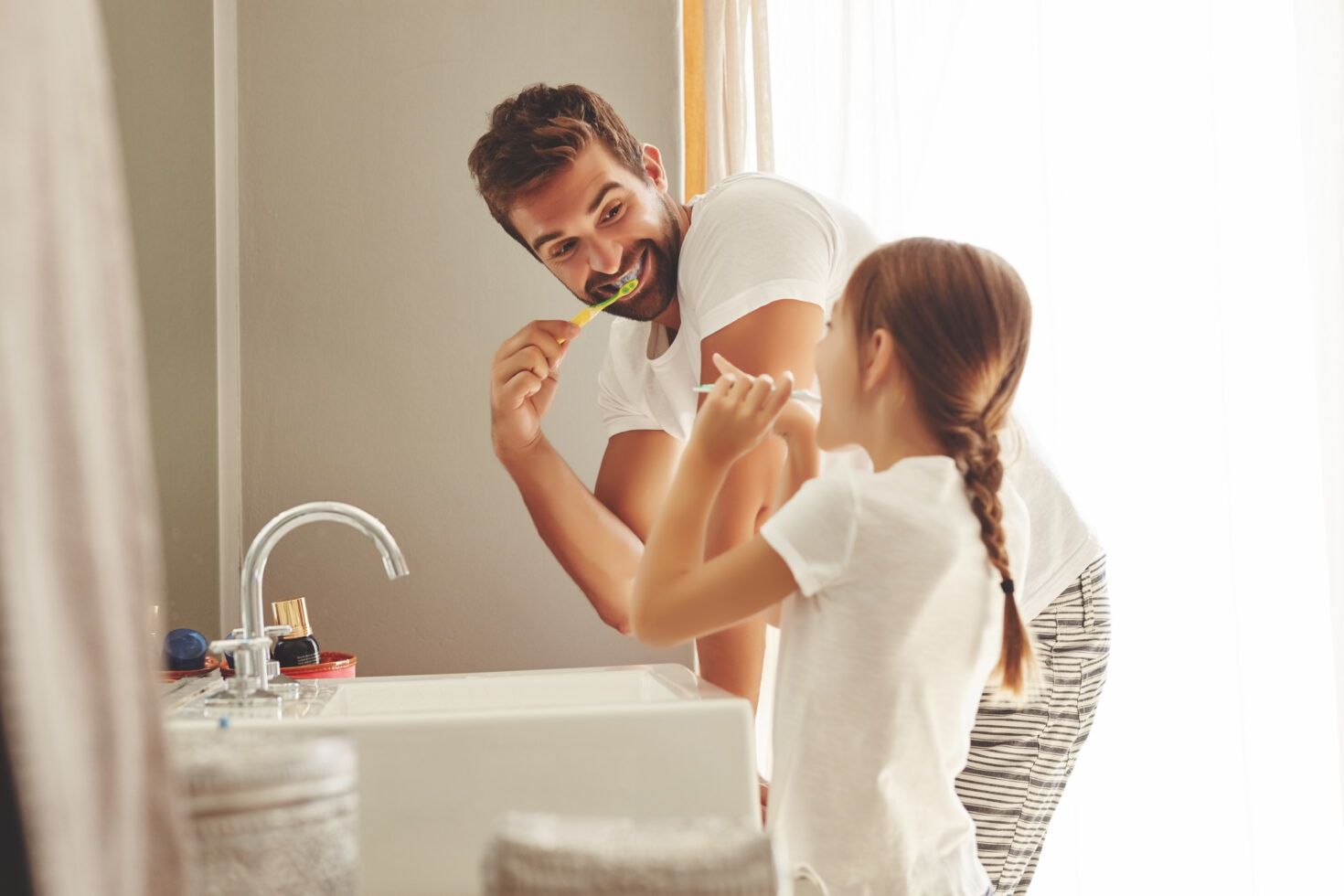 Dental Care, Father With Daughter Brush Their Teeth And In Bathroom Of Their Home. Oral Hygiene Routine, Parent With Child Use Toothbrush For Health And Wellness Mouth Protection In The Morning